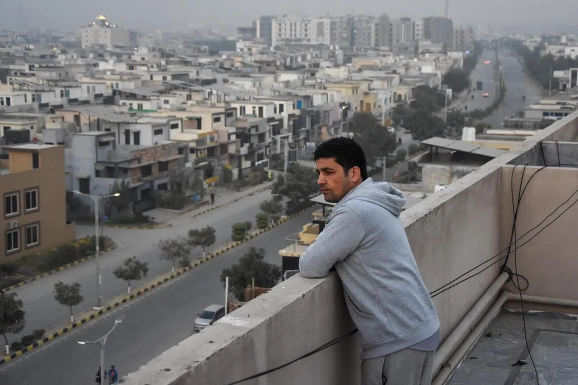 Ahmad Samim Naimi, 34, from Afghanistan's Panjshir province, who had worked as a TV presenter and press adviser, stands on the roof of his apartment building in Islamabad on Nov 28 after the US halted visa processing for Afghan nationals last week. 