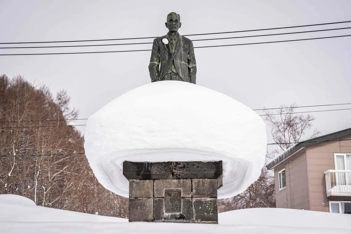 Snow resting upon the stone statue in Kutchan, in Hokkaido prefecture on Feb 19, 2026.