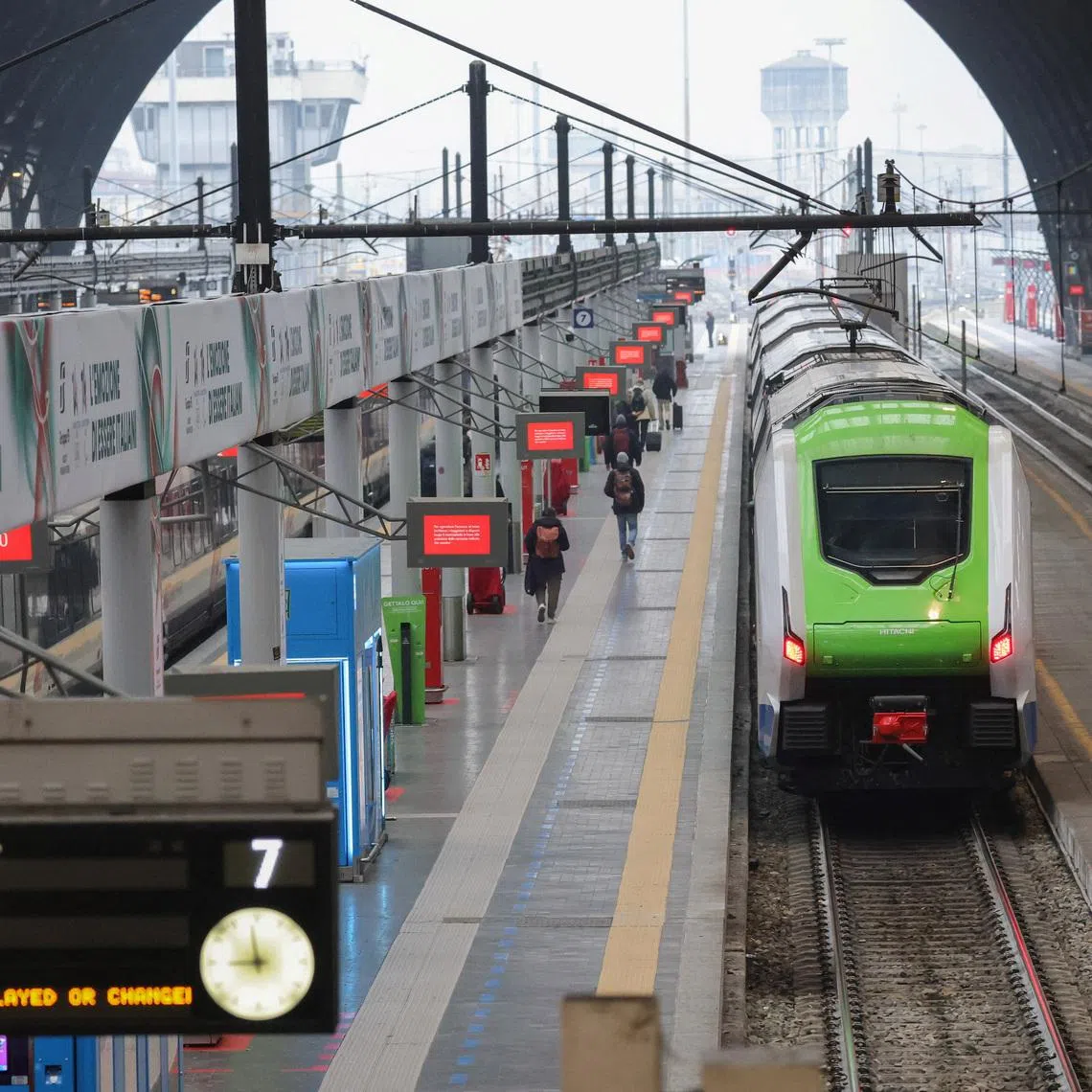 A regional train stands at the platform while passengers move along the concourse under strike-related service warnings at Milano Centrale station during a Trenord strike in Milan, Italy, February 2, 2026. REUTERS/Fabrizio Bensch