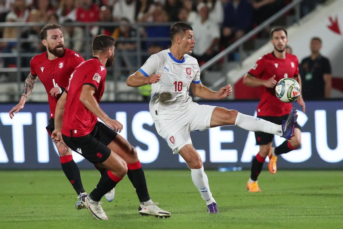 Czech Republic's Patrik Schick is marked by  Georgia's Lasha Dvali and Guram Kashia in their Nations League B Group 1 match at  Mikheil Meskhi Stadium in Tbilisi on Sept 7, 2024.