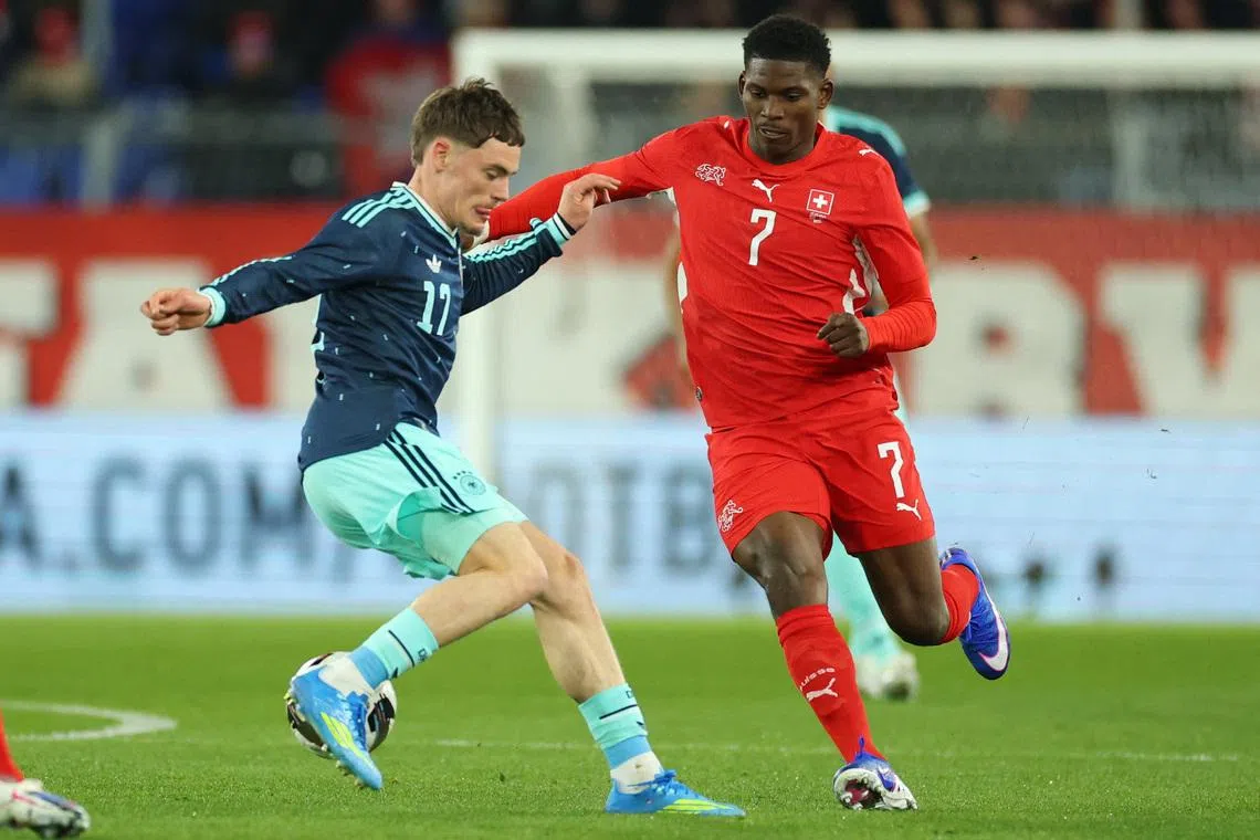 Soccer Football - International Friendly - Switzerland v Germany - St. Jakob-Park, Basel, Switzerland - March 27, 2026 Germany's Florian Wirtz in action with Switzerland's Breel Embolo REUTERS/Denis Balibouse