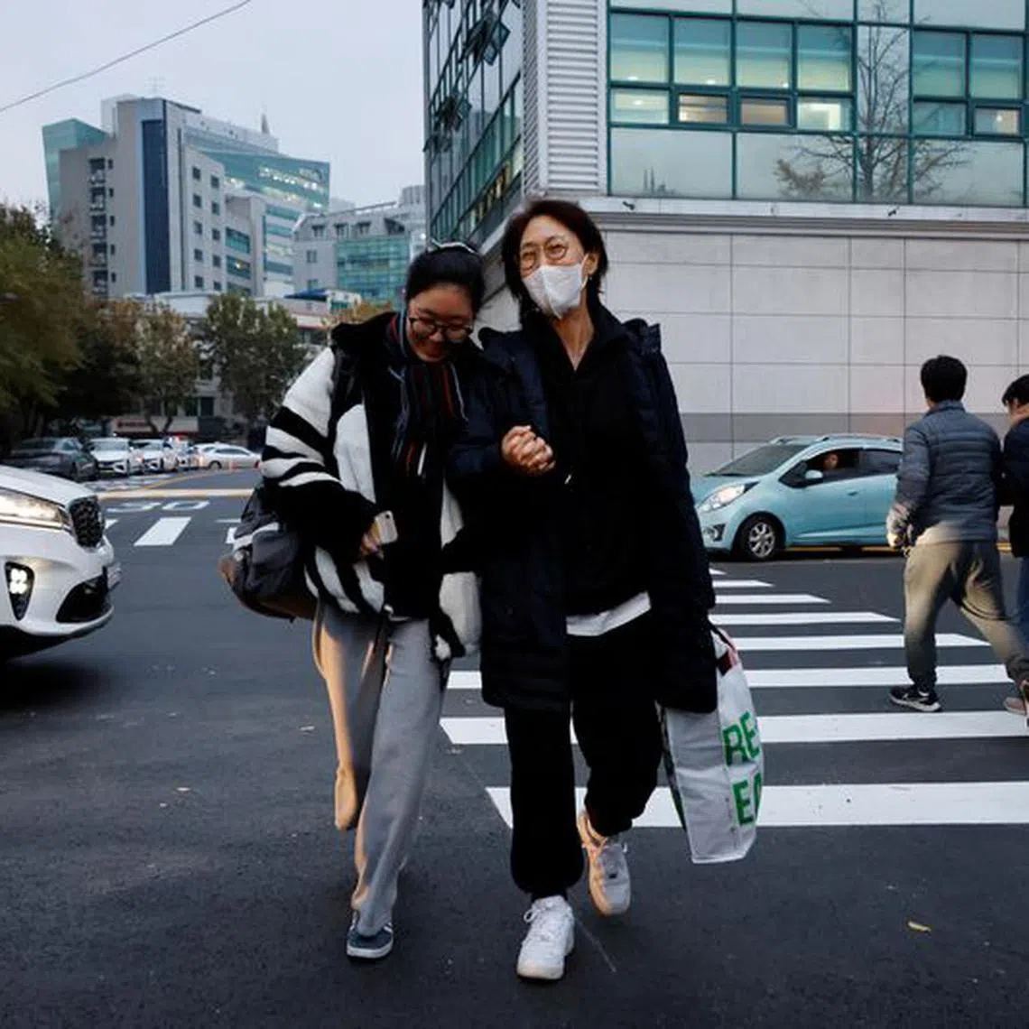 A mother holds her daughter's hand as she takes the College Scholastic Ability Test in Seoul, South Korea, November 16, 2023.   REUTERS/Kim Soo-hyeon
