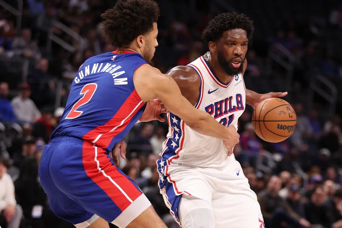 Joel Embiid of the Philadelphia 76ers drives around Cade Cunningham of the Detroit Pistons during the first half at Little Caesars Arena.
