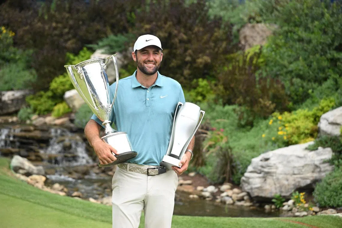 Scottie Scheffler poses with the J. K. Wadley Trophy and The Keeper after winning the BMW Championship.