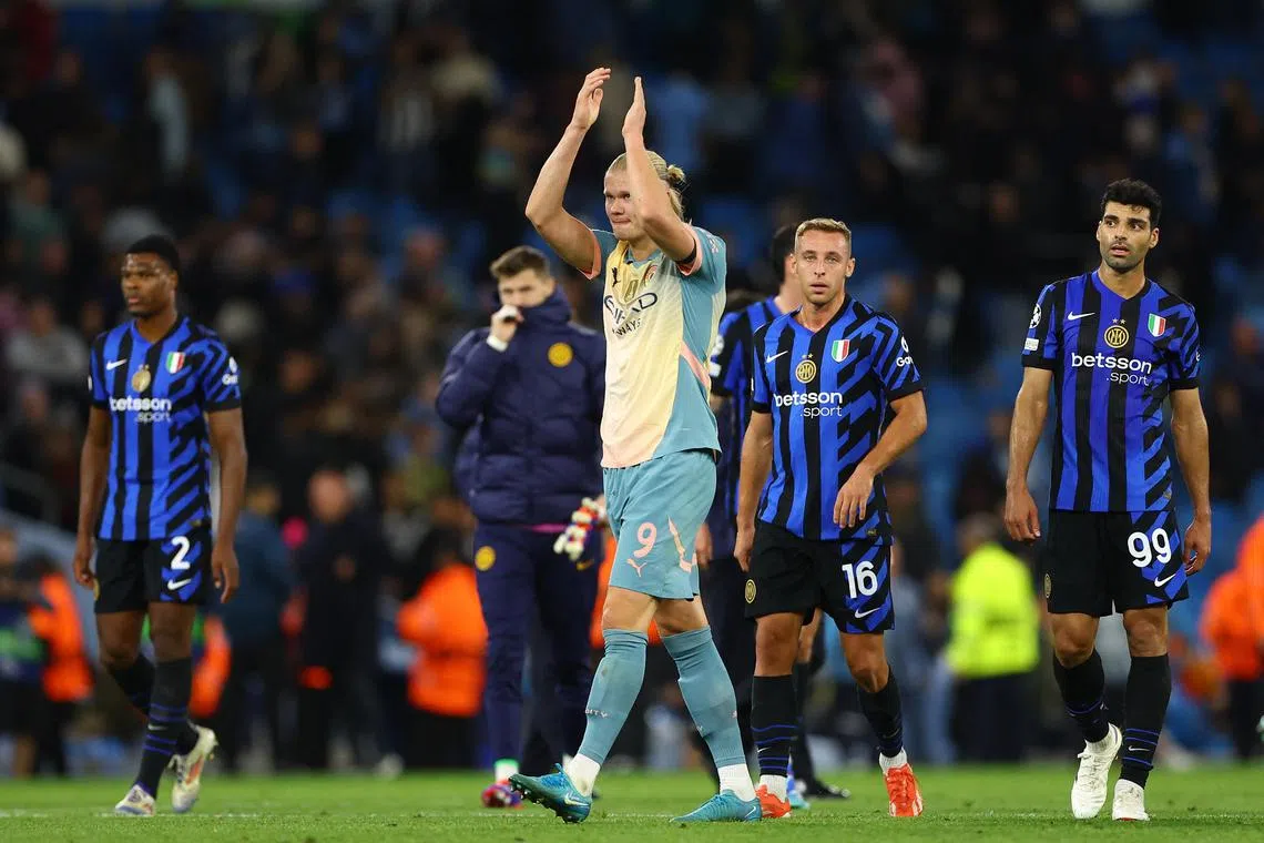 Manchester City's Erling Haaland applauds fans after the match, as Inter Milan's Mehdi Taremi and Davide Frattesi look on.