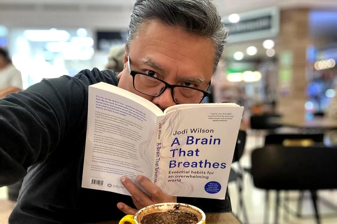 Suhaimi Yusof with A Brain That Breathes, a book he picked up during a trip to Perth.