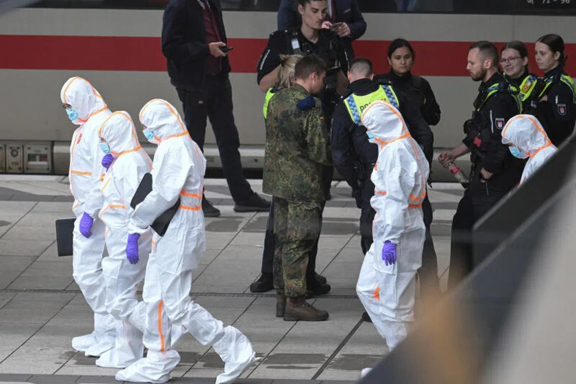 Police officers and forensic experts at Hamburg's main train station, after several people were injured in a knife attack.