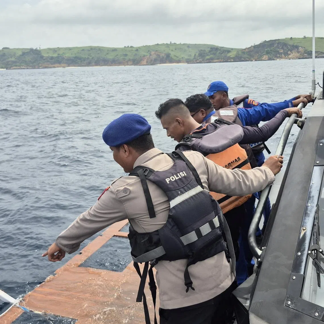 Rescue team members search for passengers missing since the night of Dec 26.