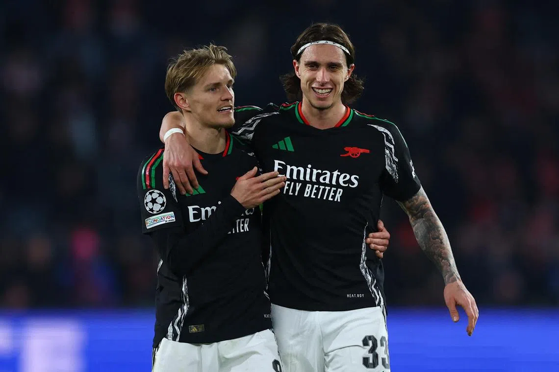 Arsenal's Martin Odegaard and teammate Riccardo Calafiori celebrate after the match.