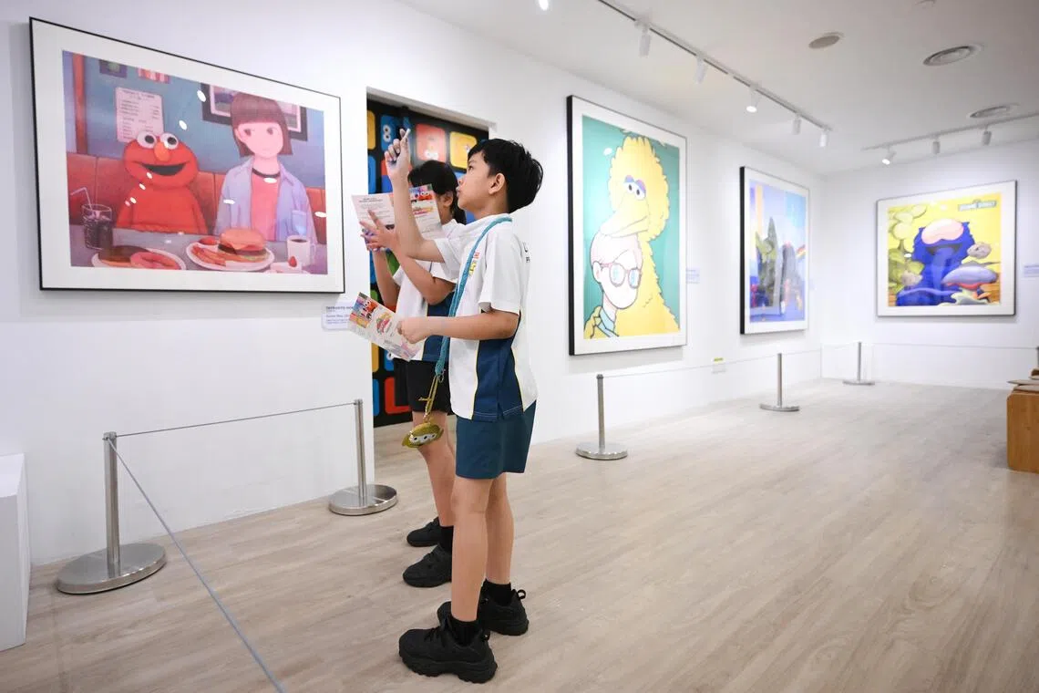 Primary 4 pupil Langit Al Fatih Norman looking at paintings in the Painting Gallery, where artists have reimagined Sesame Street characters.