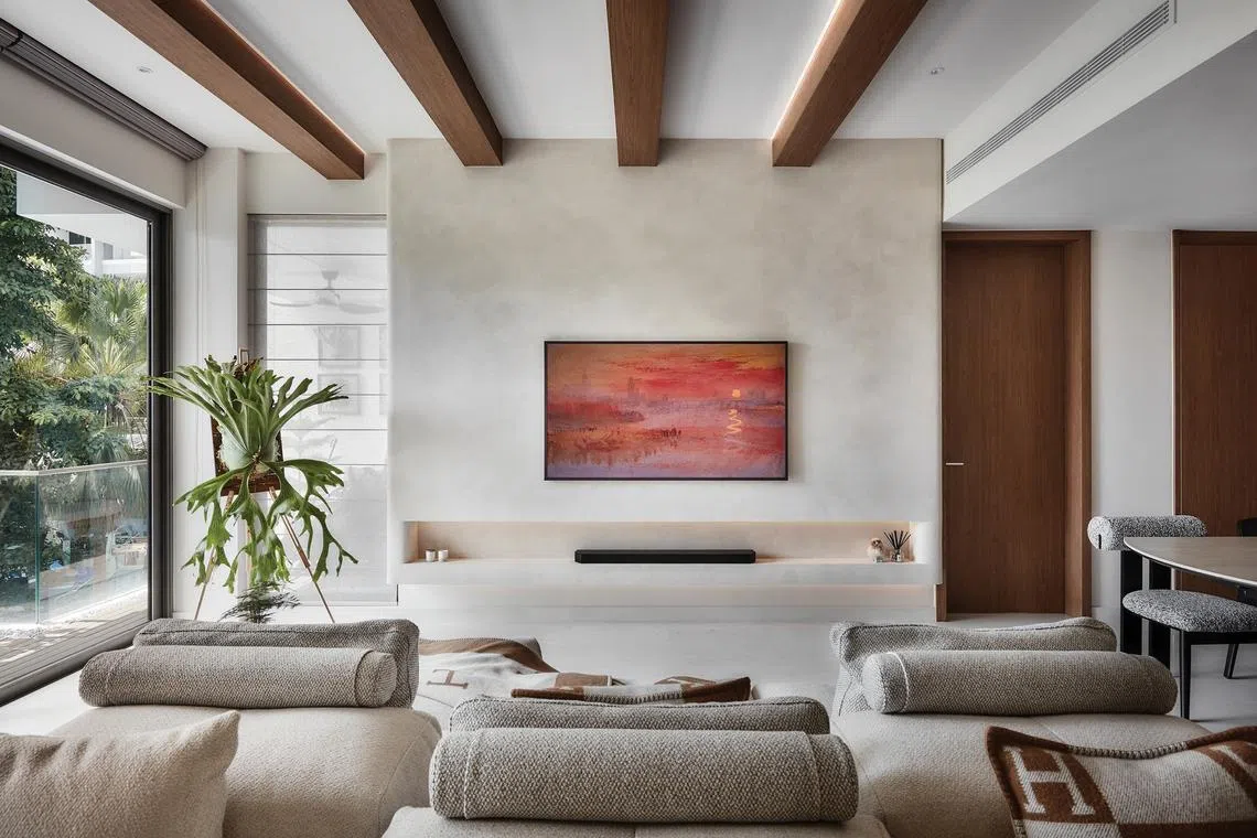 Warm wood beams and a textured wall frame the living area.