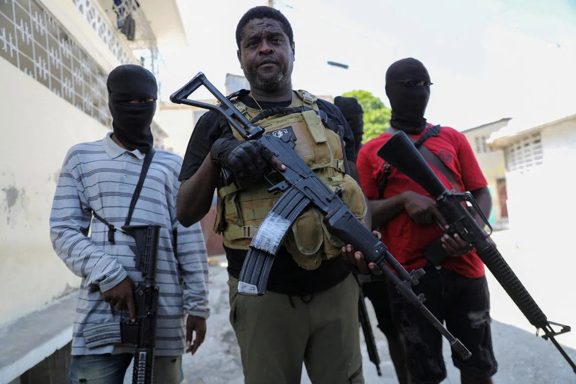 FILE PHOTO: Former police officer Jimmy \"Barbecue\" Cherizier, leader of the 'G9' gang alliance, is flanked by gang members after a press conference in Delmas 6, Port-au-Prince, Haiti March 5, 2024. REUTERS/Ralph Tedy Erol/File Photo