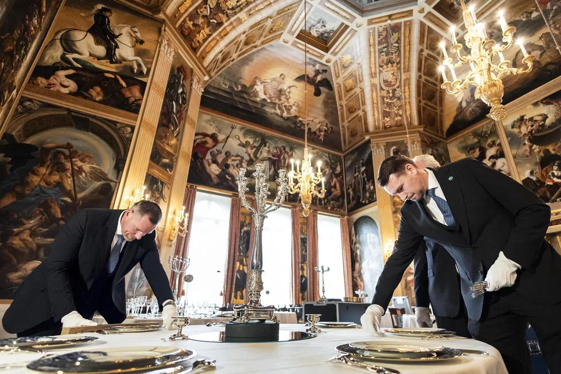 Service staff set a table as preparations are underway in the Oranjezaal ballroom in the royal palace Huis ten Bosch in The Hague, The Netherlands.
