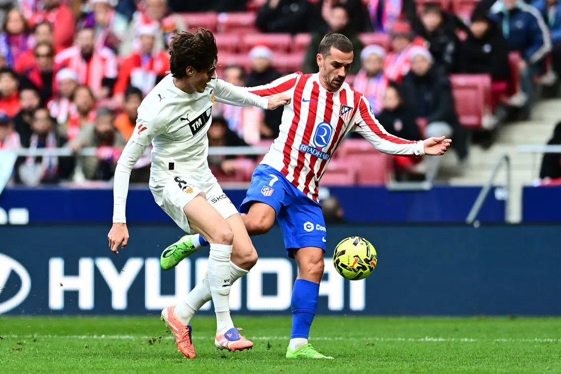 Soccer Football - LaLiga - Atletico Madrid v Valencia - Riyadh Air Metropolitano, Madrid, Spain - December 13, 2025 Atletico Madrid's Antoine Griezmann in action with Valencia's Javi Guerra REUTERS/Juan Barbosa