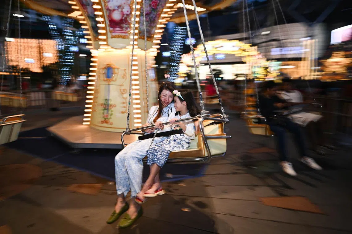 ST20241224_202430800741-Lim Yaohui-pixchristmas24/ People enjoying themselves on the European Swing at Shaw House Urban Plaza which is part of The Great Christmas Village at Orchard Road on Dec 24, 2024. The much-anticipated Great Christmas Eve Street Party is making a triumphant return, stretching 400m from ION Orchard to Ngee Ann City. It will feature live DJ performances, roving mascots, pop-up stalls, food trucks, as well as a countdown to Christmas, among other offerings. A section of Orchard Road from Paterson Road junction to Bideford Road junction will be closed to vehicular traffic on 24 December 2024 from 6pm to 2am for revellers as the countdown to Christmas Day begins at 8pm. (ST PHOTO: LIM YAOHUI)