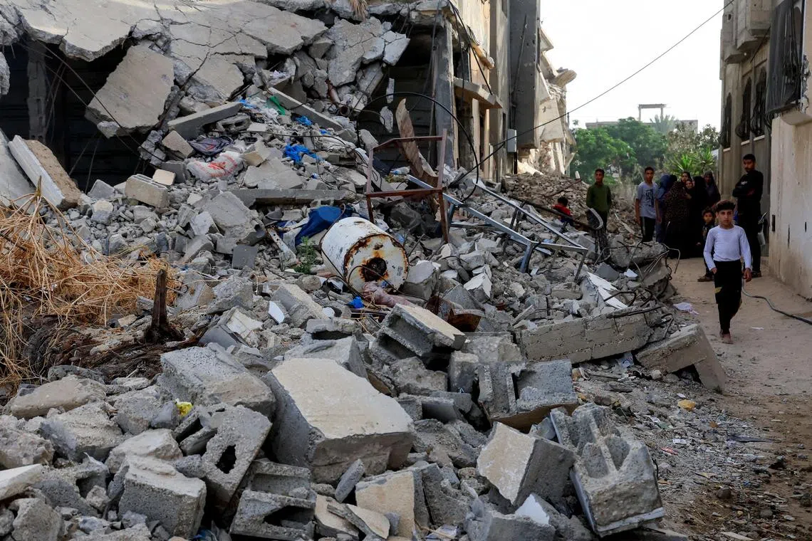 Palestinians inspect the site of an Israeli strike, in Khan Younis, southern Gaza Strip, May 19, 2025.