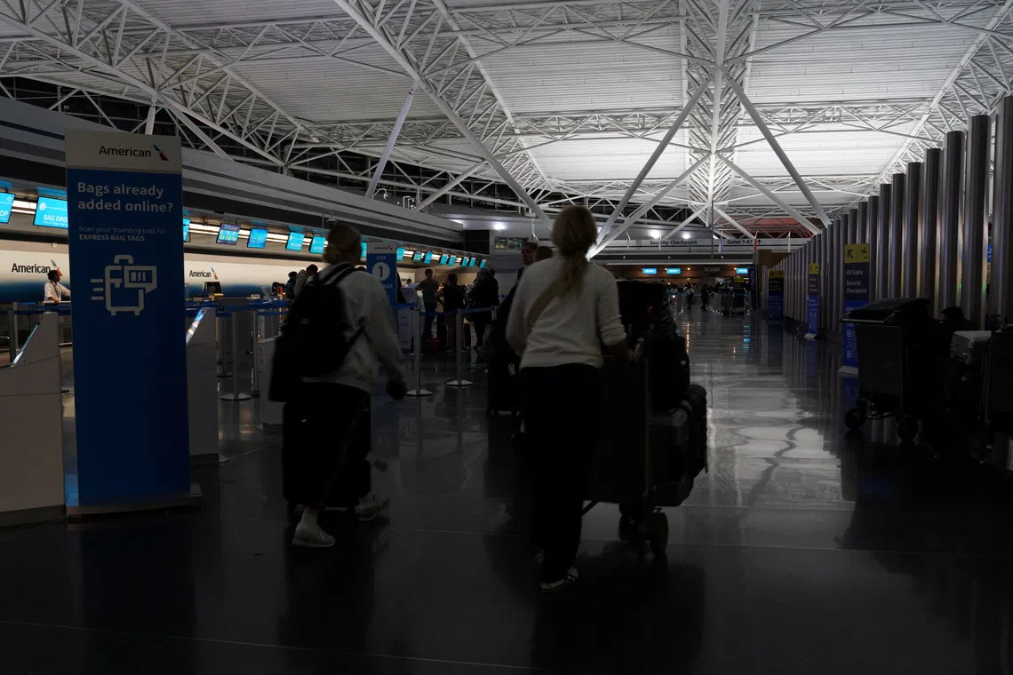 Travelers arrive at the American Airlines check-in area in Terminal 8 at John F. Kennedy International Airport, ahead of U.S. President Donald Trump's reinstatement of a new travel ban barring citizens of 12 countries from entering the U.S., in New York, U.S., June 8, 2025. REUTERS/Bing Guan/File Photo