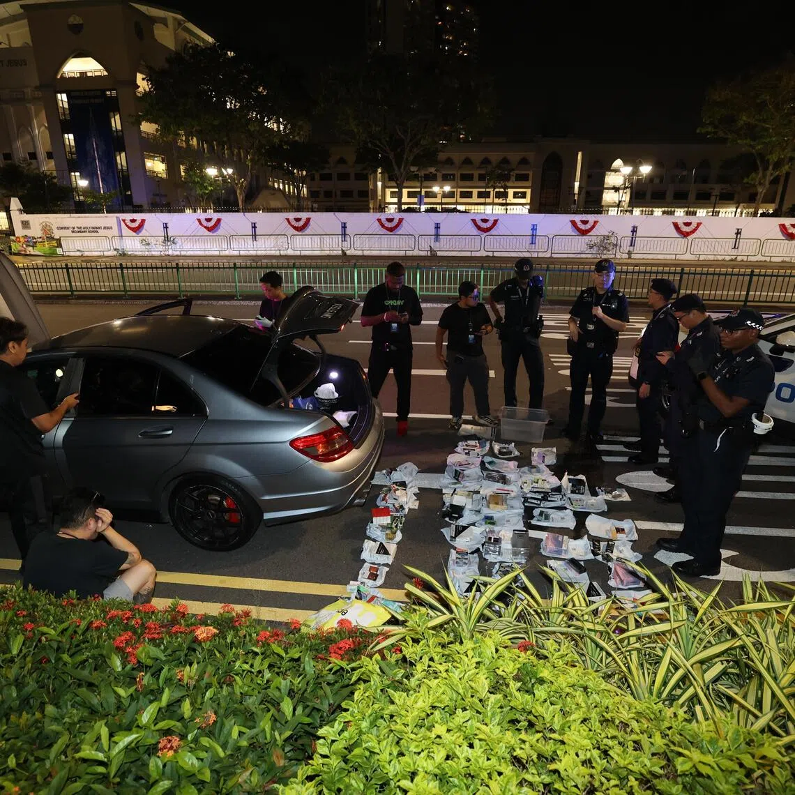 Officers were seen removing e-cigarettes from sealed boxes and sorting them into evidence bags next to the vehicle.