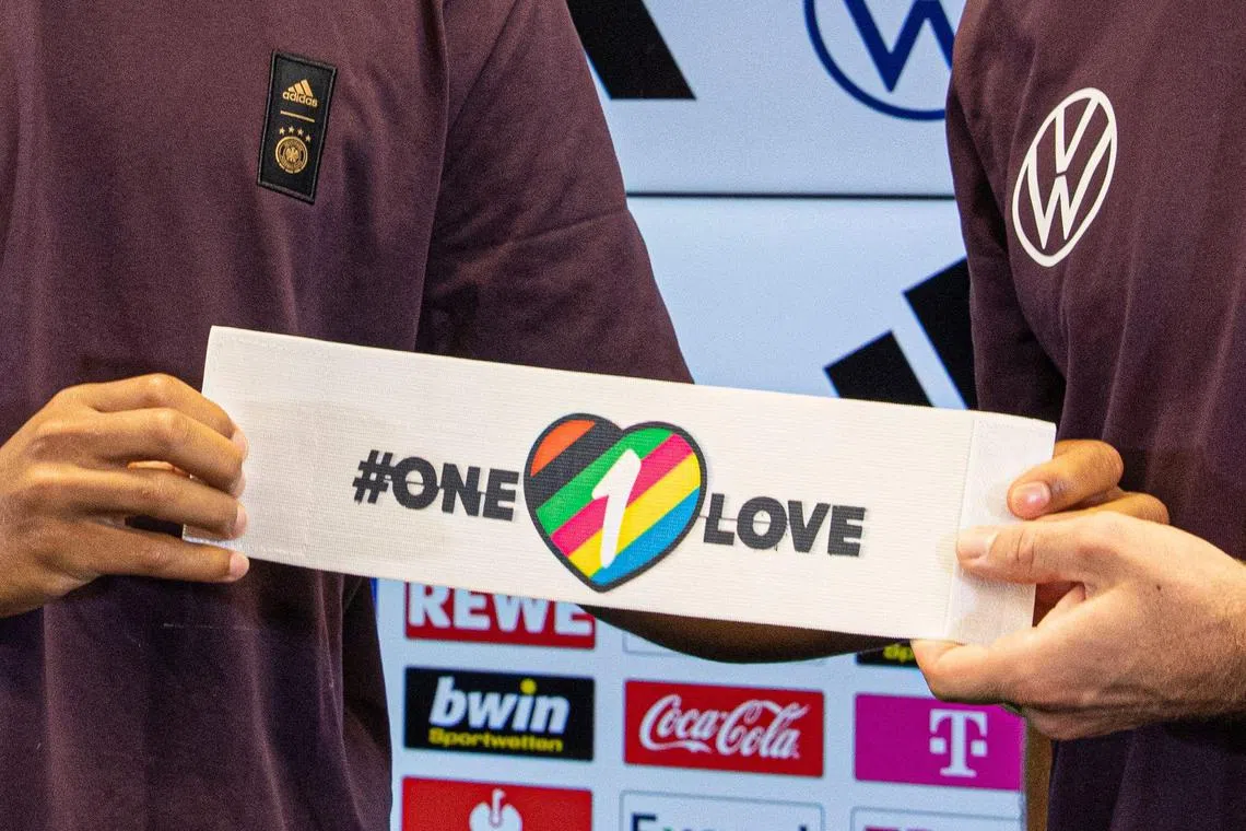 The captain's armband with the "One Love" symbol being presented during a Germany press conference in September.  Seven countries including Germany, however, abandoned their plan to wear the armband at the Nov 20-Dec 18 World Cup after threats of disciplinary action from Fifa.