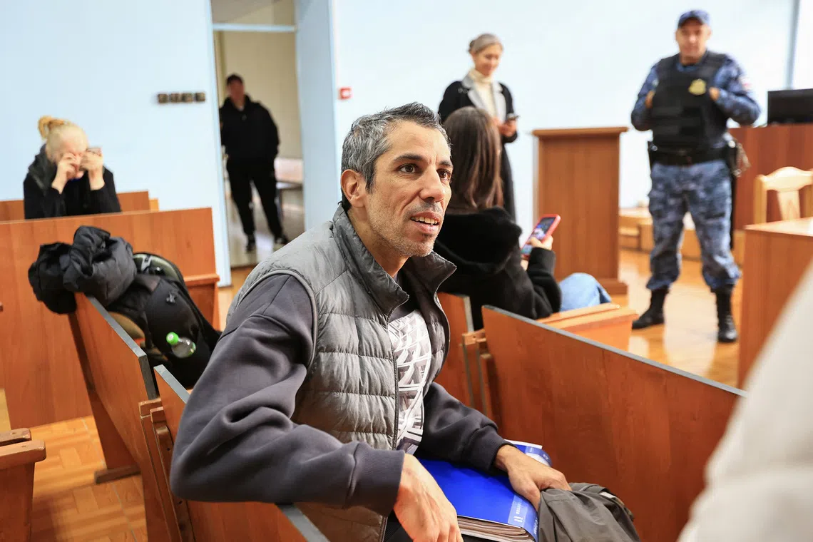 French cyclist Sofiane Sehili, who was found guilty of illegally crossing the Russian border while attempting to break the world record for the fastest cycle crossing of the Eurasian landmass and freed by a court that ordered him to pay a fine, sits in a courtroom in the far eastern settlement of Pogranichniy, Russia, October 23, 2025. REUTERS/Tatiana Meel