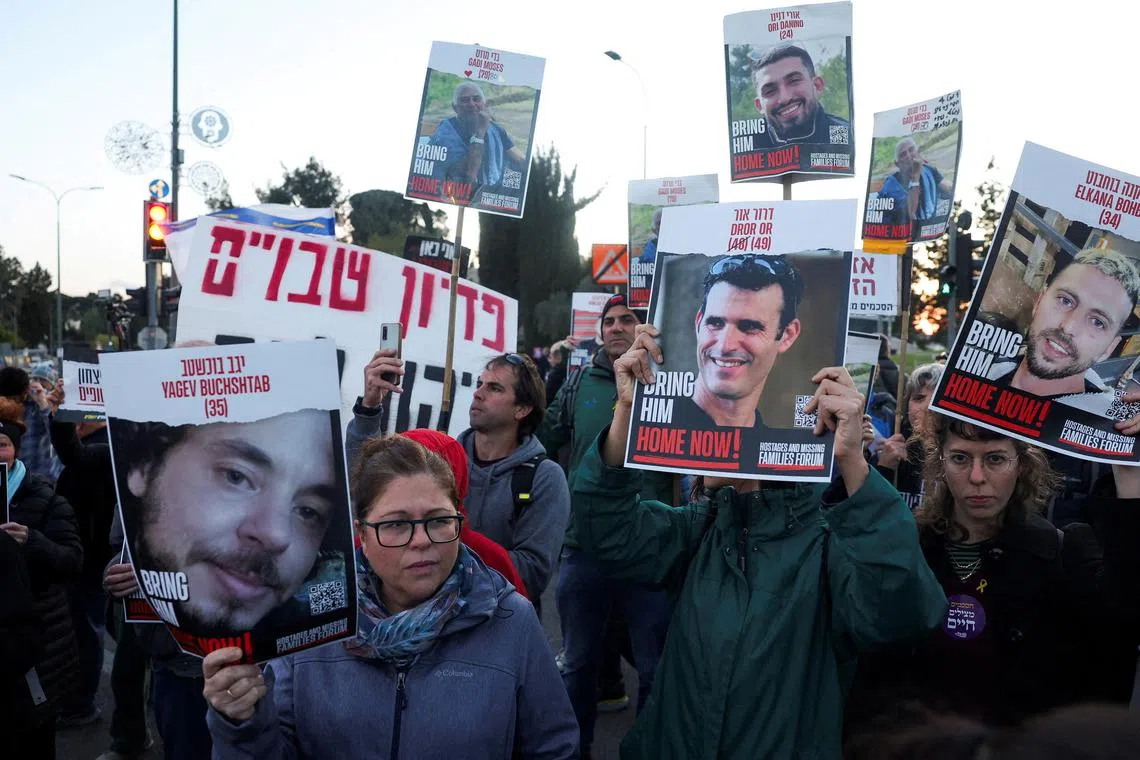 FILE PHOTO: A woman holds a photo of Israeli hostage Yagev Buchshtab as people hold up pictures of other hostages as they attend a protest calling for a deal and the release of the hostages held in Gaza, amid the ongoing conflict between Israel and the Palestinian Islamist group Hamas in Gaza, outside Prime Minister's office in Jerusalem, April 9, 2024. REUTERS/Ronen Zvulun/File Photo
