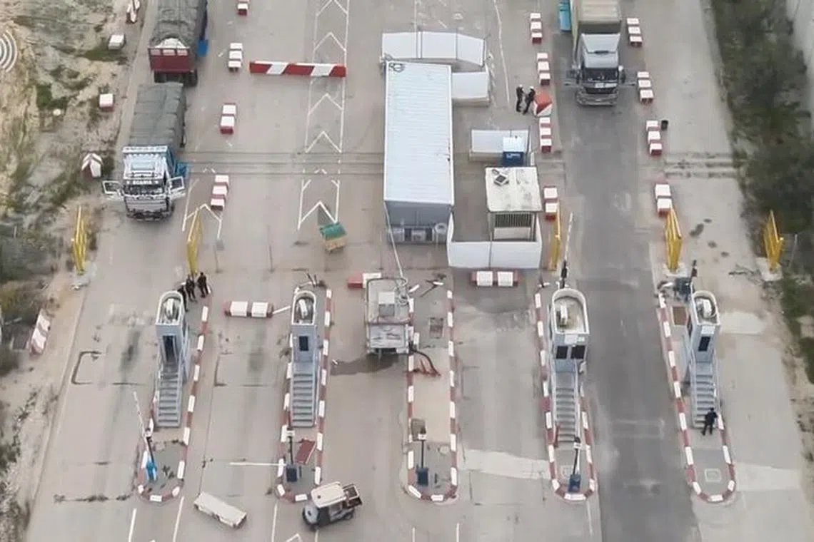 Humanitarian aid trucks wait in line to be inspected at the Kerem Shalom crossing, amid the ongoing conflict between Israel and the Palestinian Islamist group Hamas, on the border between Israel, Gaza and Egypt in this still image taken from video released December 12, 2023.    COGAT via X/Handout via REUTERS /File Photo