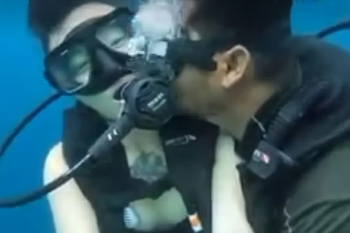 A Facebook photo that went viral shows the diving instructor, after removing his regulator, kissing the Chinese tourist on the cheek.