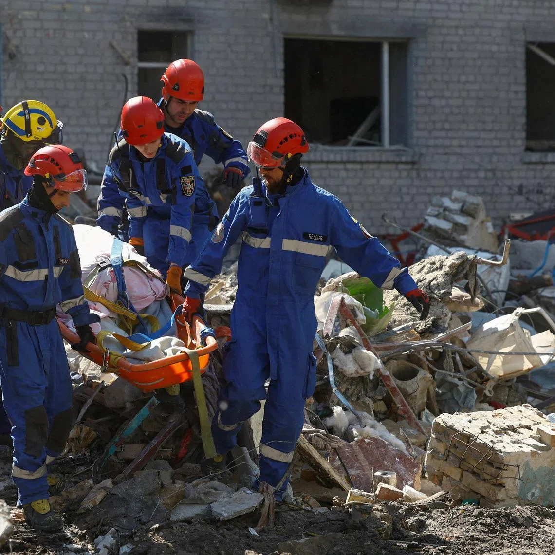 Rescuers carry the body of a killed person found under debris during overnight Russian attacks, in Kyiv, Ukraine, on July 2.
