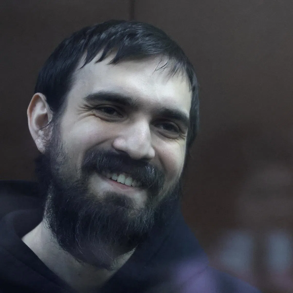 Russian comedian Artemy Ostanin reacts inside an enclosure for defendants as he attends a court hearing after his March 2025 arrest over a stand‑up performance, in Moscow, Russia, February 4, 2026. REUTERS/Anastasia Barashkova