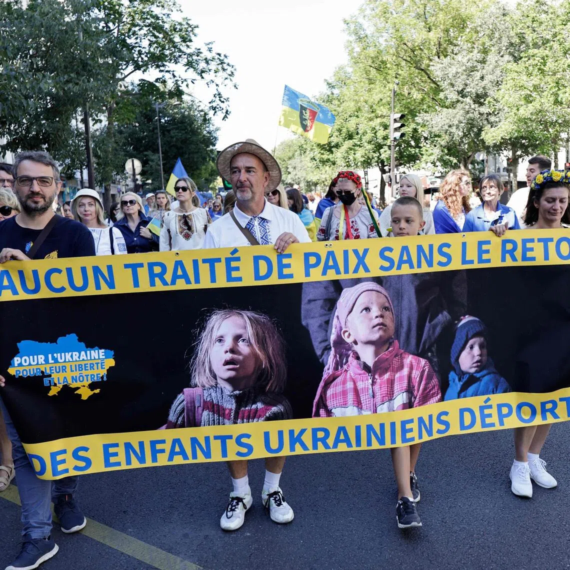 People hold a banner reading "No peace treaty without the return of Ukrainian deported children", during a demonstration in Paris, France, in August 2025.