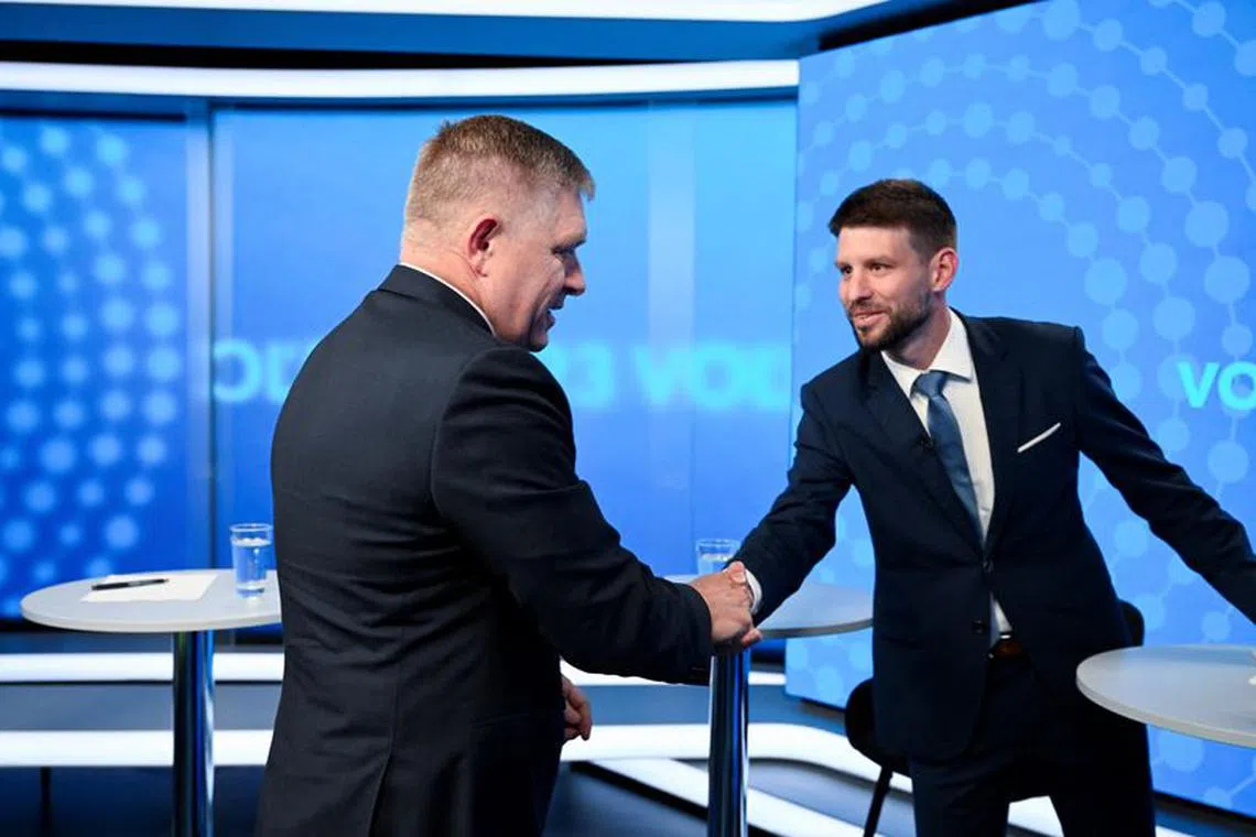 Robert Fico, leader of the SMER-SSD party, and Michal Simecka, leader of the Progressive Slovakia party, greet each other with a handshake before a televised debate at TV TA3, prior to the Slovak early parliamentary election, in Bratislava, Slovakia, September 26, 2023. REUTERS/Radovan Stoklasa