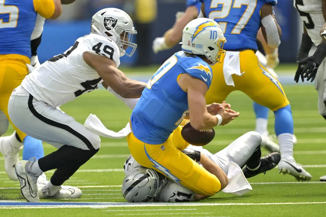 FILE PHOTO: Sep 8, 2024; Inglewood, California, USA; Los Angeles Chargers quarterback Justin Herbert (10) is sacked by Las Vegas Raiders defensive end Charles Snowden (49) and linebacker Robert Spillane (41) in the first half at SoFi Stadium. Mandatory Credit: Jayne Kamin-Oncea-Imagn Images/File Photo