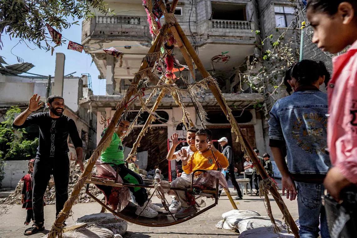 Children celebrate on the first day of the Muslim holiday of Eid al-Fitr, after the end of the holy month of Ramadan, in Deir el-Balah, in the central Gaza Strip, on April 10, 2024, 