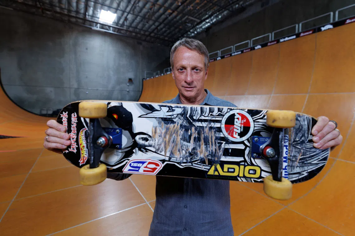 Tony Hawk holds the skateboard he used to land the first-ever \"900\" at the 1999 X Games, a milestone that transformed skateboarding from subculture to global sport and made Hawk its defining icon. The Birdhouse \"Falcon 2\" board helped etch the trick into history and will be auctioned by Julien's to help raise money for his charity \"The SkatePark Project\" in Vista,  California, U.S., August 19, 2025.  REUTERS/Mike Blake