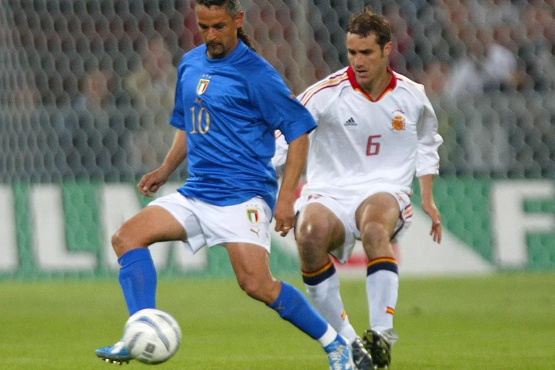 FILE PHOTO: Italy's Roberto Baggio (L) is shadowed by Ivan Helguera of Spain during a friendly match in Genoa April 28, 2004. REUTERS/Stefano Rellandini/File Photo