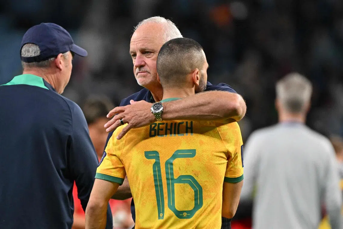 Australia's coach Graham Arnold consoles defender Aziz Behich after the quarter-final match against South Korea.