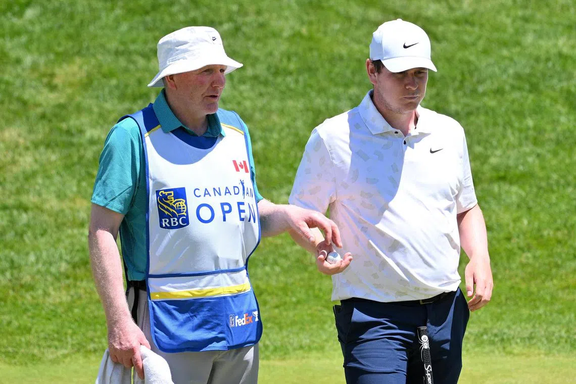 Robert MacIntyre receives his golf ball from his father Dougie, who is filling in as caddie in the second round of the Canadian Open.