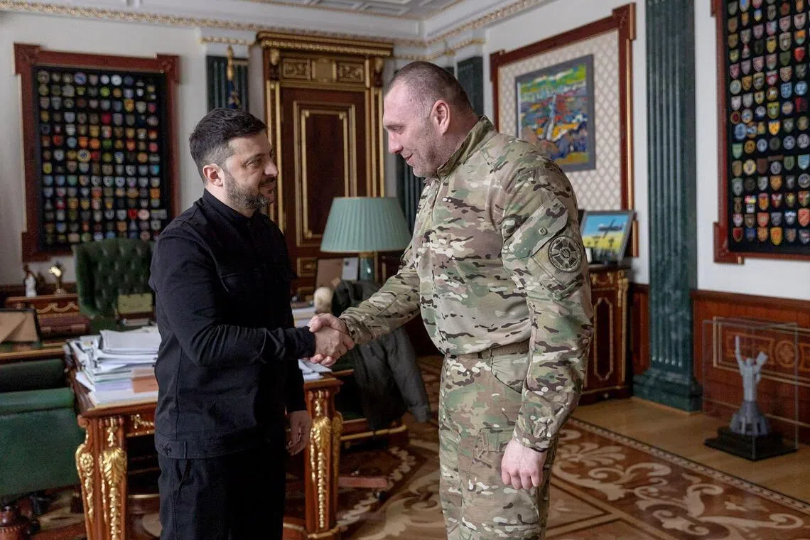 Ukraine's President Volodymyr Zelensky (left) shakes hands with former Ukraine's head of the Security Service Vasyl Maliuk (right) during a meeting in Kyiv.