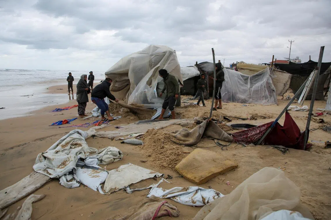 Displaced Palestinians inspect a damaged tent following rising sea levels and heavy rainfall, amid the ongoing conflict between Israel and Hamas, in Khan Younis in the southern Gaza Strip, November 25, 2024. REUTERS/Hatem Khaled