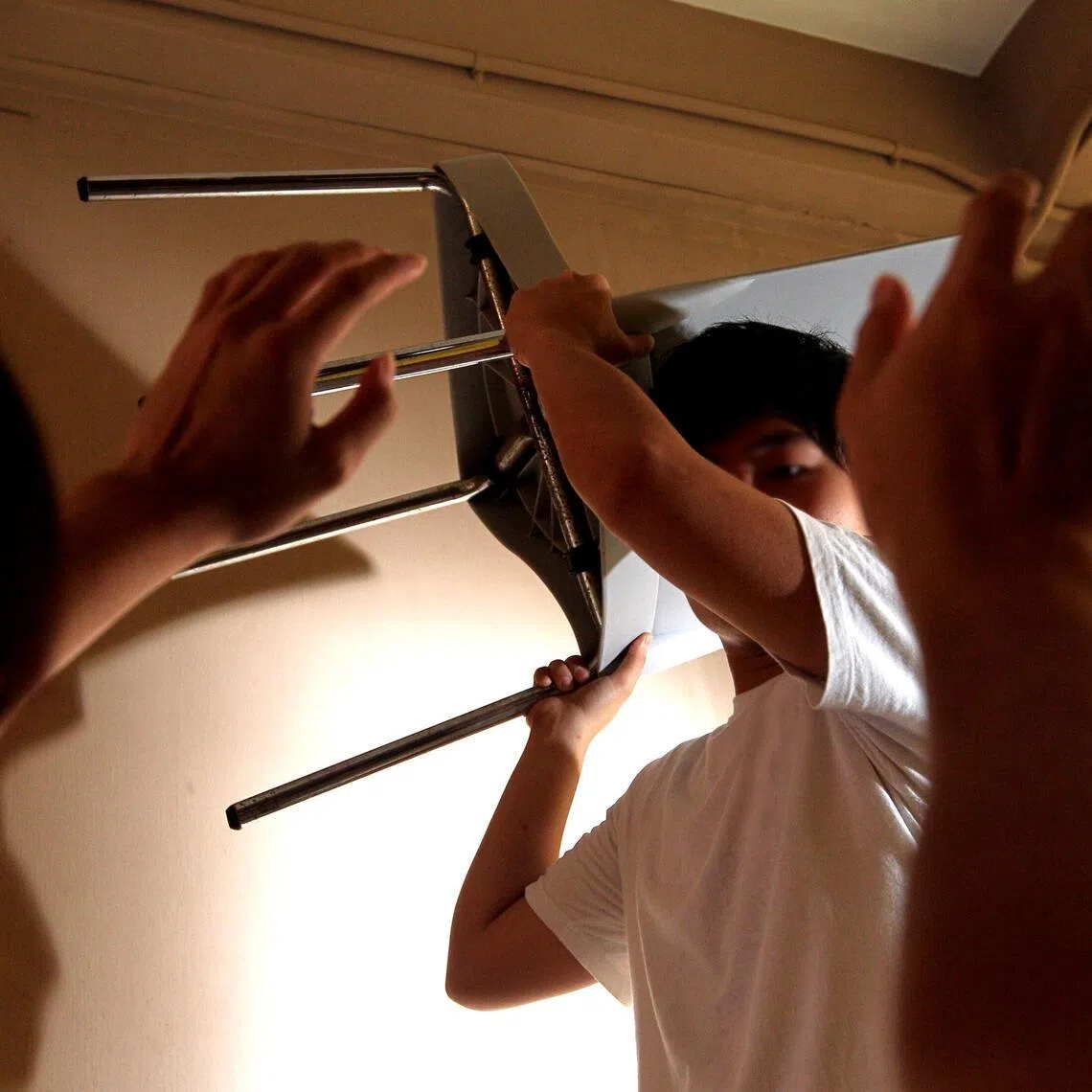 Posed photo of a school boy lifting a chair and trying to hit another boy. It is to illustrate an article on school bullying.
