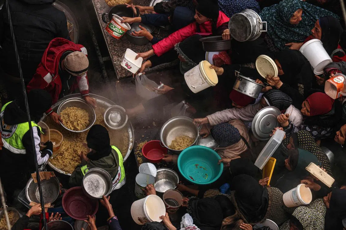 Palestinians wait for food rations at a donation point in Rafah, in the southern Gaza Strip.