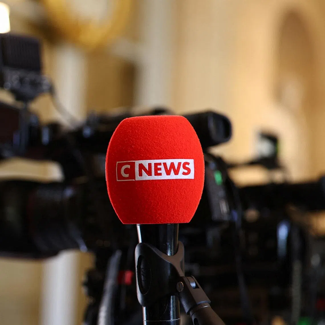 The logo of CNEWS, a French private national 24-hour news television channel, is seen on a microphone as journalists work at the National Assembly in Paris, France, April 27, 2026. REUTERS/Abdul Saboor