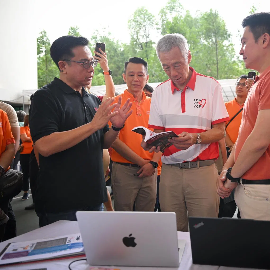 ST20240707_202492071791/ilfamily07/Shintaro Tay/

Senior Minister Lee Hsien Loong and Mr Henry Kwek (far right) interacting Mr Laurence Liew (in black), director, AI Innovation, AI Singapore and Mr Tan Wai Chong (in orange next to Mr Liew), Kebun Baru grassroots leader helming the AI initiative at Kebun Baru Community Club on July 7, 2024.
ST PHOTO: SHINTARO TAY