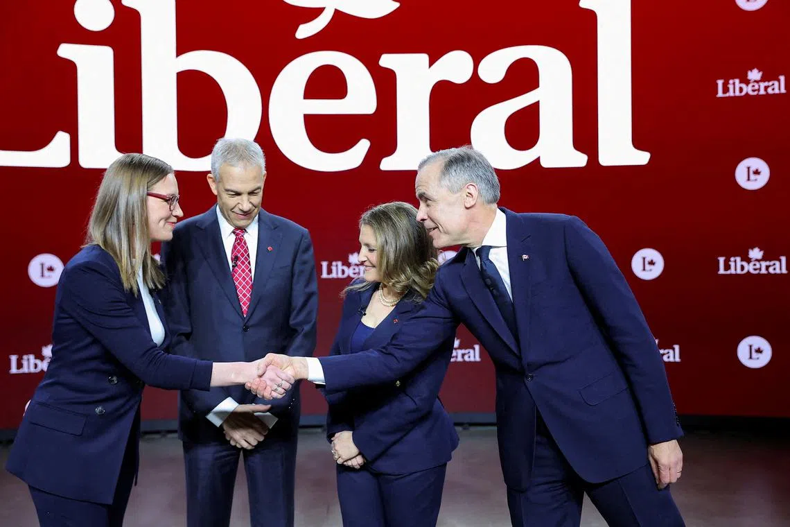 FILE PHOTO: Canada's Liberal Party leadership candidates, former House leader Karina Gould shakes hands with former Bank of Canada governor Mark Carney, near former Liberal MP Frank Baylis, and former Deputy Prime Minister and Finance Minister Chrystia Freeland, on the day of an English language debate ahead of the March 9 vote to replace Prime Minister Justin Trudeau, in Montreal, Quebec, Canada, February 25, 2025.  REUTERS/Evan Buhler/File Photo
