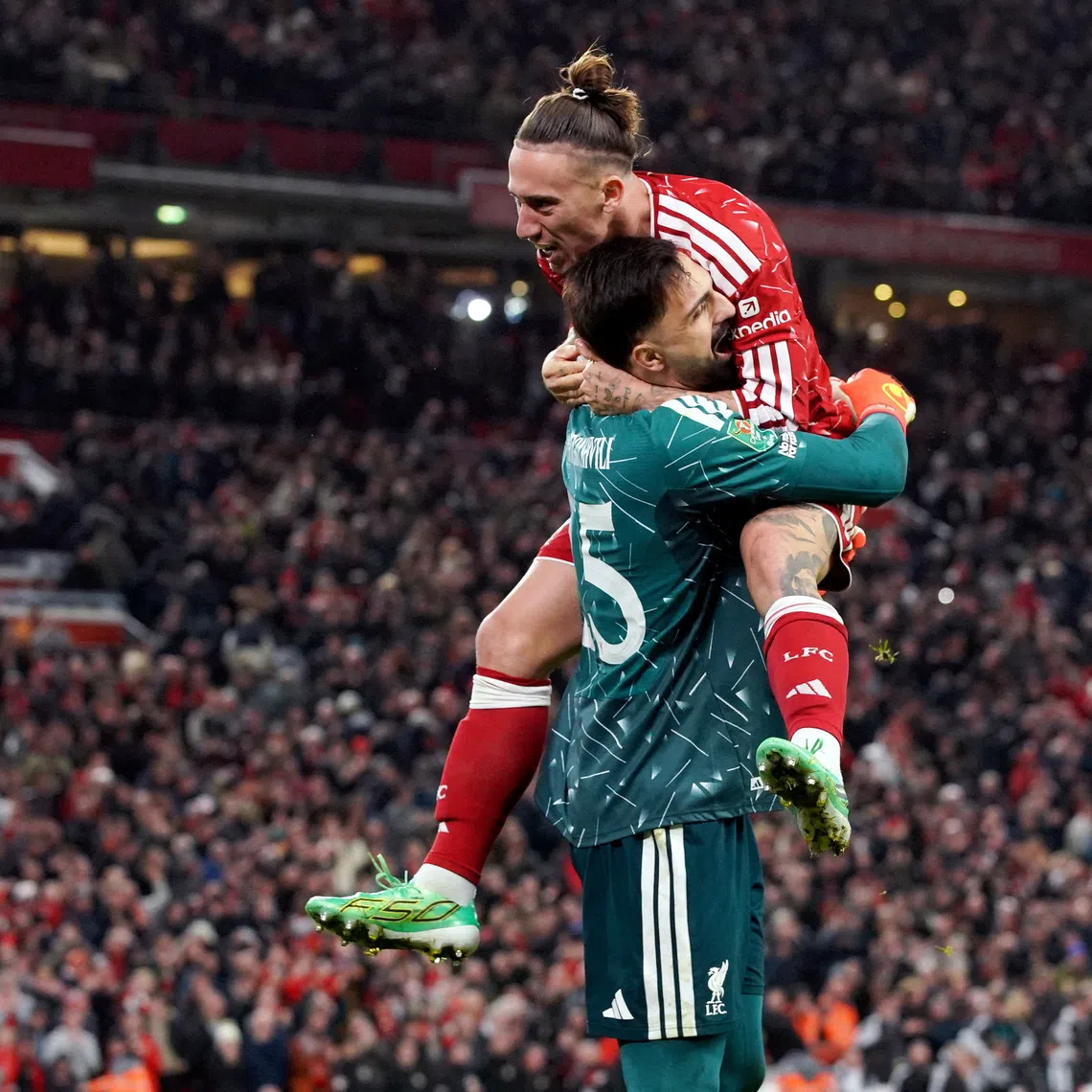 Liverpool’s Giorgi Mamardashvili and Kostas Tsimikas celebrate winning the penalty shoot-out.