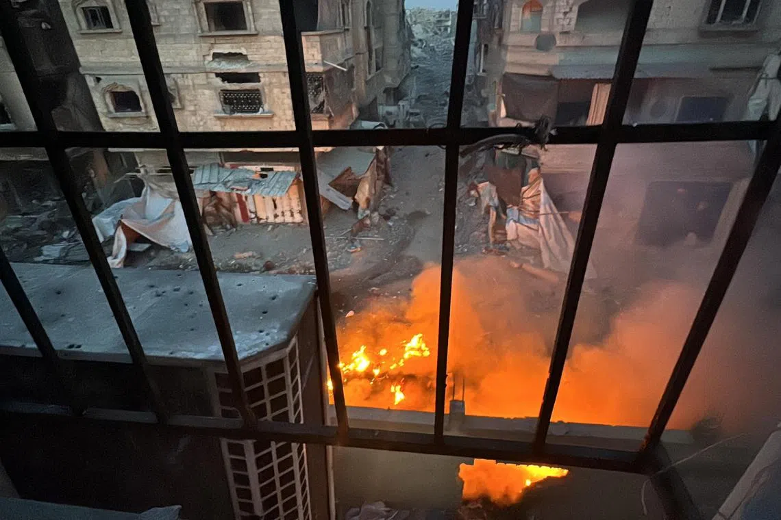 A fire burns as seen through a window from Kamal Adwan Hospital in Beit Lahiya in the northern Gaza Strip  on Dec 18.
