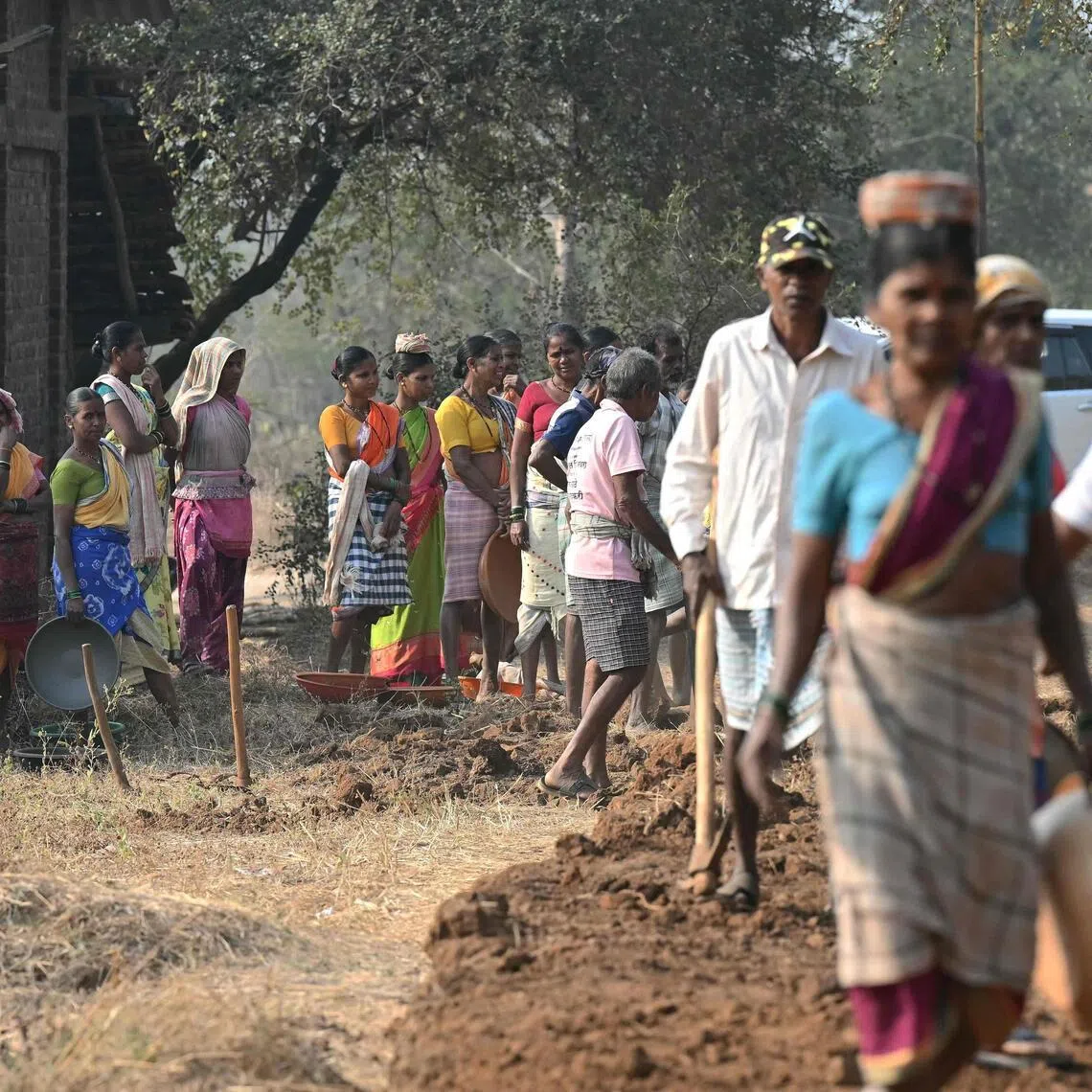This photograph taken on February 14, 2026 shows wage-labourers under Mahatma Gandhi National Rural Employment Guarantee Act (MGNREGA) waiting for their turn at a road-construction site at Balapur Dolkarpada village in Maharashtra's Palghar district. India's economy grew at a faster pace than expected in the last quarter of 2025 driven by solid consumer spending, data showed on February 27, using a new framework that calculates economic output more accurately.
