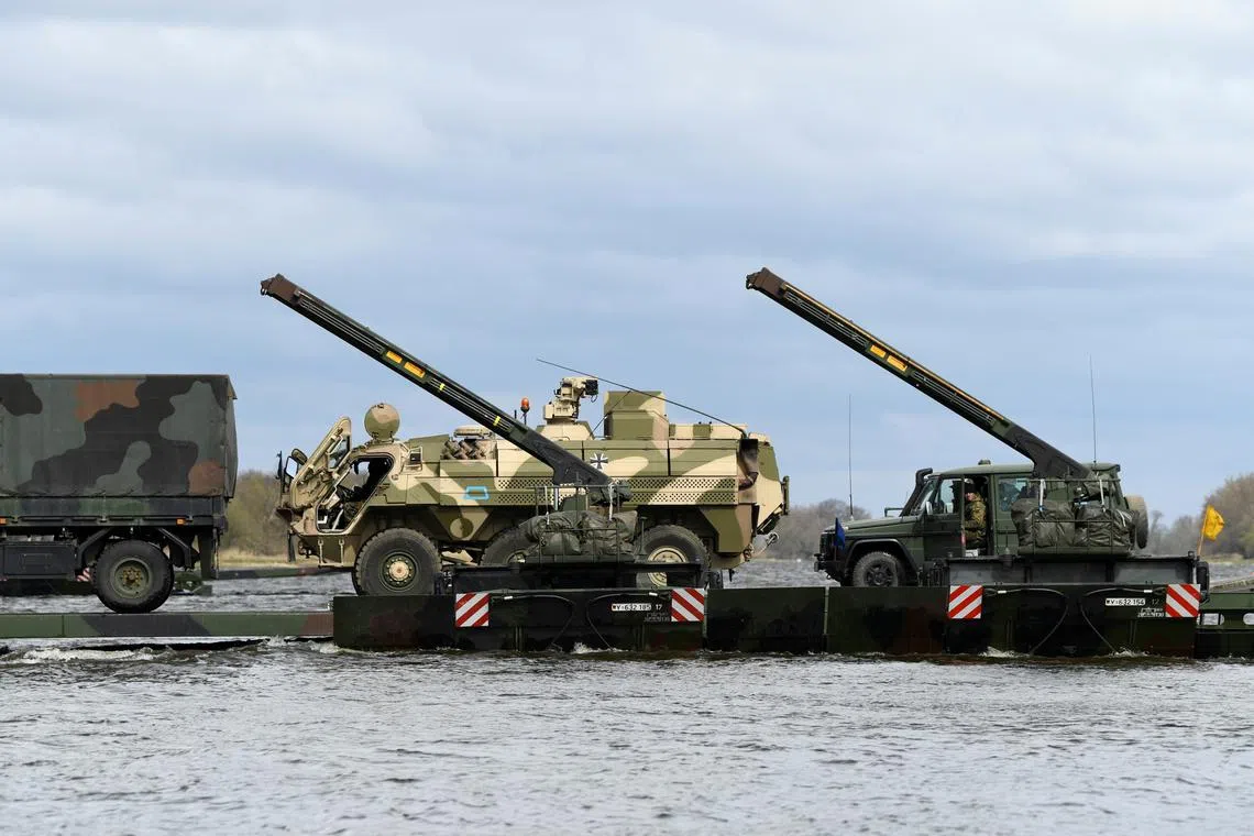 FILE PHOTO: Soldiers and military vehicles of the 37th Panzergrenadier Brigade \"Free State of Saxony\" of the German Army Bundeswehr, intended for the 'Very High Readiness Joint Task Force' (VJTF) of the 'NATO Response Force' (NRF), are ferried across the Elbe river using the Amphibian M3 floating bridge, during the 'Wettiner Schwert' exercise near Storkau, Germany April 2, 2022. REUTERS/Annegret Hilse/ File Photo