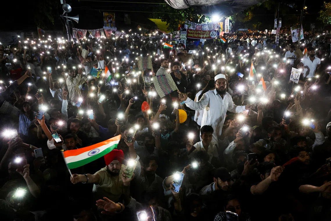 Supporters of the Cockroach Janta Party chant slogans and wave their mobile phones with their flashlights during a sit-in protest at Jantar Mantar in New Delhi, on July 19.