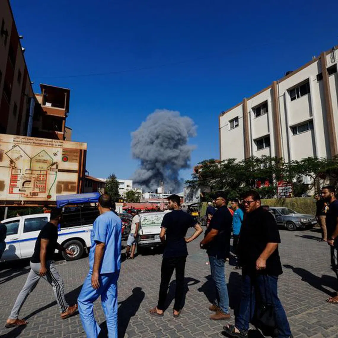 FILE PHOTO: Palestinians react as smoke rises following Israeli strikes, as the conflict between Israel and Palestinian Islamist group Hamas continues, in Khan Younis in the southern Gaza Strip, October 26, 2023. REUTERS/Mohammed Salem/File Photo